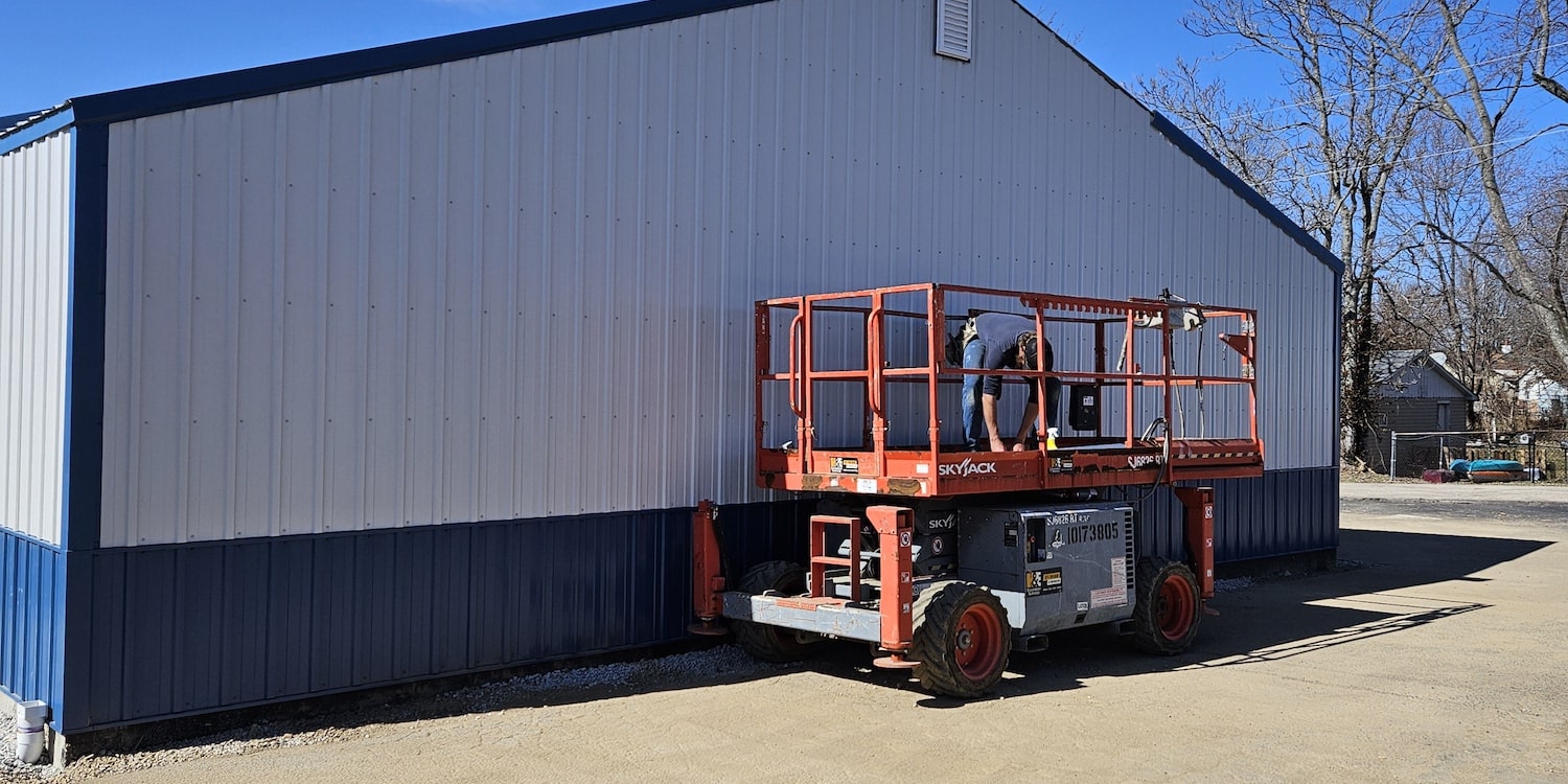 A side view of a commercial project showing white siding with blue siding below it